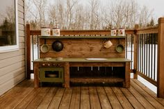 an outdoor kitchen on a deck with pots and pans