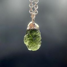 This unusual pendant features a rough piece of forest green Moldavite. The cap and bail have been electroformed copper and plated in fine silver. Moldavite is thought to have been formed by condensed rock vapors after a meteorite impact. Moldavite belongs to the Tektite group of minerals, which is a small family of natural glass rocks. The pendant measures 23mm long including the bail by 11mm wide and 10mm deep. Your pendant will arrive packaged in a black paper gift box.    Please select the si Moldavite Necklace, Gift Ideas Jewelry, Moldavite Pendant, Raw Stone Jewelry, Glass Rocks, Hemp Jewelry, Electroformed Jewelry, Buy Crystals, Handcrafted Artisan Jewelry