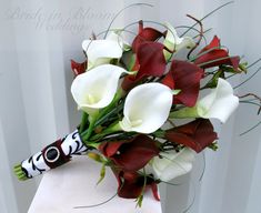 a bouquet of white and red flowers sitting on top of a piece of paper in front of a wall