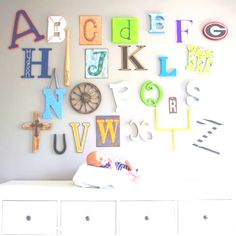 a white dresser topped with lots of letters and numbers on it's side wall