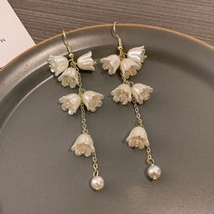 ✦ Drape yourself in the exquisite elegance of our crystal tulip flower dangle earrings, crafted to enhance the beauty of weddings and engagements. The intricate design of crystal tulip flowers exudes sophistication, adding a touch of romantic charm to your bridal ensemble. These earrings are meticulously crafted for those special moments, ensuring you shine with grace on your wedding day. The delicate dangle silhouette enhances the overall allure, creating a timeless accessory that complements y Elegant Flower Shaped Crystal Earrings With Flower Charm, Elegant Crystal Earrings With Flower Charm, Elegant Crystal Earrings With Flower Charm Gift, White Drop Earrings For Mother's Day, Mother's Day White Drop Flower Earrings, Elegant Dangle Jewelry With Flower Decoration, Elegant Dangle Flower Earrings For Mother's Day, Elegant Mother's Day Earrings With Flower Charm, Elegant Flower Charm Earrings For Mother's Day