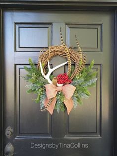 a wreath with deer antlers and berries hangs on the front door