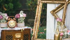 there is a mirror, vases and an old clock on the table