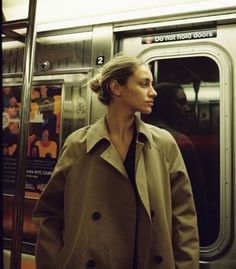 a woman standing in front of a subway car