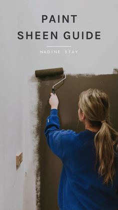 a woman painting the side of a wall with a paint roller on it's handle