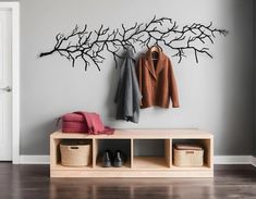 a coat rack with two coats hanging on it next to a pair of shoes and purses