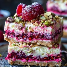 raspberry and pistachio cheesecake bars stacked on top of each other