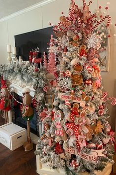 a decorated christmas tree in front of a fireplace with stockings and candy canes on it