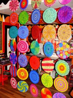 a room filled with lots of colorful plates hanging from the ceiling