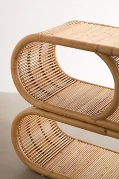 two tables made out of wicker sit side by side on the floor in front of a white wall