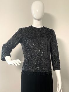 This beautiful beaded top from Jeri-Jo made in Hong Kong is ready to add some sparkle to your evening.  The top is fully lined with a wool base.  It is heavily beaded in sequins, seed beads and fringe beads throughout and along the hemline.  It completely zips down the back and has a hook and eye closure.  Sleeves are 3/4 length.  No stretch, fits the mannequin perfectly 35 X 26 X 33.  No size tag.  Maybe a few missing beads, but in great wearable condition.   Measurements taken with top laying Glamorous Party Tops With Beaded Fringe, Glamorous Beaded Fringe Top For Party, Fitted Party Tops With Fringe, Elegant Fitted Tops With Rhinestone Fringe, Fitted Fringe Top For Party, Black Rhinestone Fringe Top For Evening, Beaded Tops For Night Out In Fall, Beaded Tops For Fall Night Out, Elegant Beaded Tops For Party Season