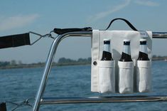 three bottles are hanging from the back of a boat