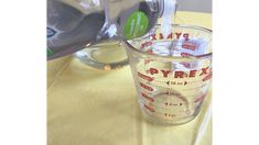 a measuring cup filled with liquid next to a blender