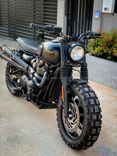 a black motorcycle parked on the street next to a building