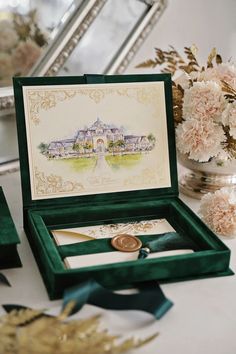 a green box with a gold medal in it sitting on a table next to flowers