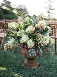 a vase filled with flowers sitting on top of a lush green field