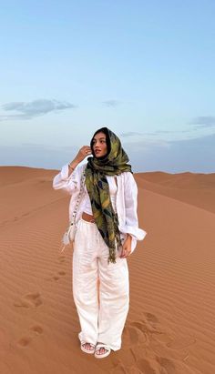 a woman standing in the middle of a desert