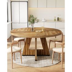 a round wooden table with four chairs around it in a white kitchen, and an area rug on the floor