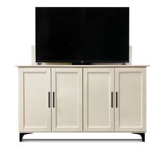 a flat screen tv mounted on top of a white cabinet