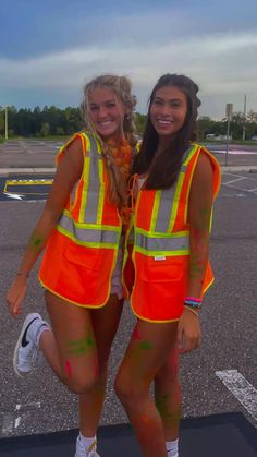 two women in orange safety vests standing next to each other