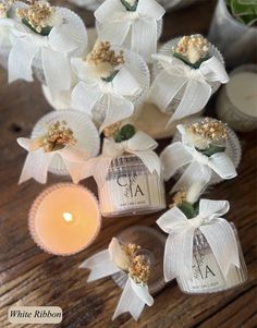 some white flowers and candles on a wooden table