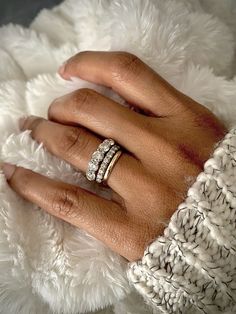 a woman's hand with two rings on top of her finger and the other ring is