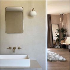 a white sink sitting under a bathroom mirror next to a wall mounted faucet