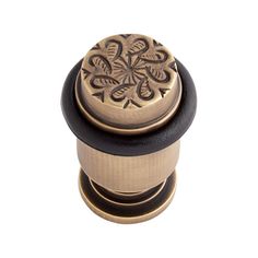 an antique style cabinet knob with a flower design on the center and black rubber band