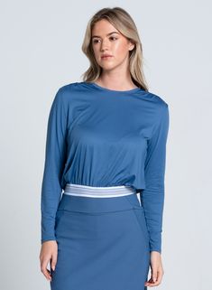 Easy on the eyes and even easier to throw on. The perfect lifestyle throw over to wear on the court or out in the world. Featuring a classic stripe elastic band bottom and ruched shoulder panels for a touch of feminine flair. Sporty Tops With Upf 50+, Spring Athleisure Tops With Elastic Waistband, Fitted Blue Tops With Elastic Waistband, Sporty Stretch Top With Elastic Waistband, Fitted Blue Top With Contrast Stripes, Perfect Lifestyle, Tennis Shop, Throw Over, Dress Gift