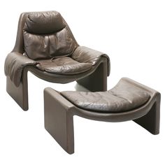 two leather chairs and one ottoman with footstool in the shape of a reclining chair