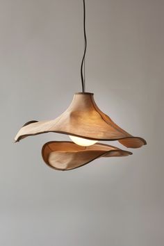 a wooden light hanging from a ceiling fixture with two lights on each side of it