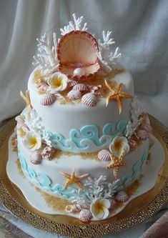 a three tiered cake decorated with shells and seashells