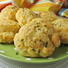 some biscuits are on a green plate with white polka dots and a colorful napkin is in the background