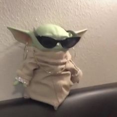 the baby yoda doll is wearing sunglasses