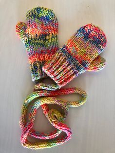 multicolored knit mittens and leash laying on white surface