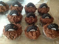 chocolate cupcakes with white and black frosting on top sitting on a plastic tray