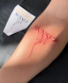 a woman's arm with red ink that has been drawn on it and is sitting next to a piece of paper