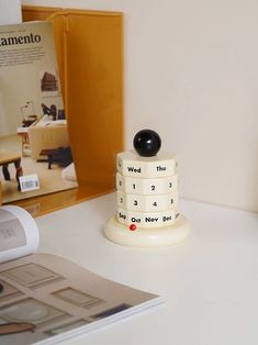 a stack of three stacked cakes sitting on top of a white table next to a magazine