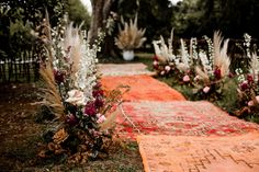 an outdoor ceremony with flowers and rugs