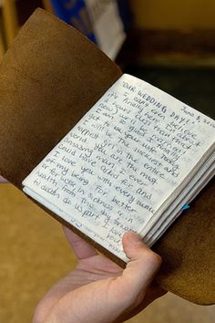 a person holding a book with writing on it and an article in the bottom right corner