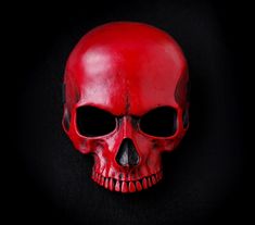 a red skull with black eyes on a black background