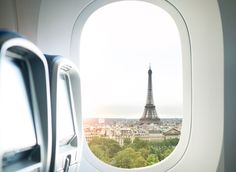 an airplane window looking out at the eiffel tower