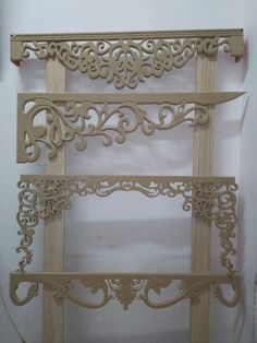 three wooden shelves with carved designs on them