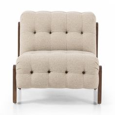 an upholstered chair with wooden legs and buttons on the back, in beige fabric