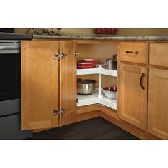 an open cabinet in the corner of a kitchen with pots and pans on it