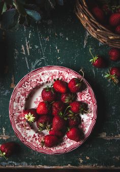 a plate with strawberries on it next to some baskets