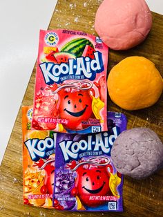 three different flavors of kool aid candy on a cutting board next to an orange