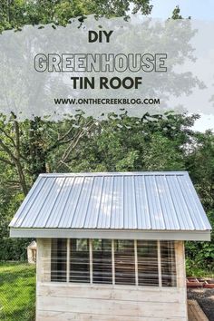 a small shed with the words diy greenhouse tin roof on it and trees in the background