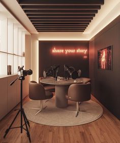 a round table with two chairs and a camera in front of it that says share your story