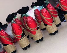 several red and black stuffed animals are tied up with twine to make them look like they're wearing hats